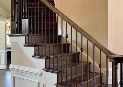 A brown, black, and white staircase leading into the second floor of the home.