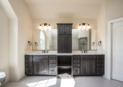 Double sink for couples with dark brown cabinets and large mirrors.